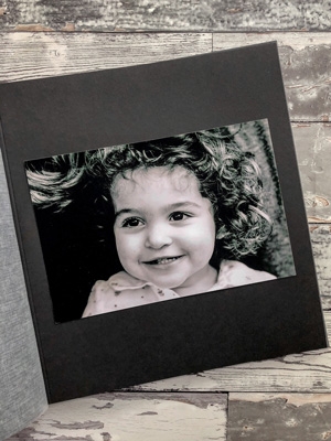 czarno-białe zdjęcie naklejone na czarnej karcie w albumie
